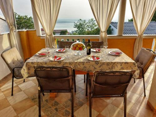 a dining room table with chairs and a table with wine glasses at Apartments Dumic Crikvenica in Crikvenica