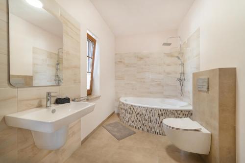biała łazienka z wanną i umywalką w obiekcie Pensjonat Urszuli 89-606 Charzykowy ul Turystyczna 39 w Charzykowach