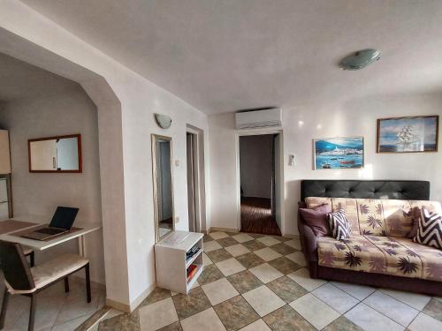 ein Wohnzimmer mit einem Sofa und einem Schreibtisch in der Unterkunft Apartments Dumic Crikvenica in Crikvenica