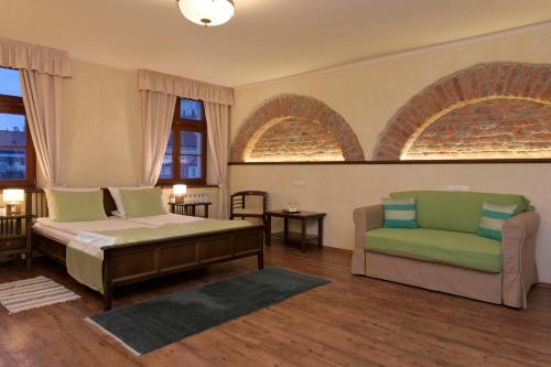a bedroom with a bed and a couch and windows at La Fresca in Kroměříž