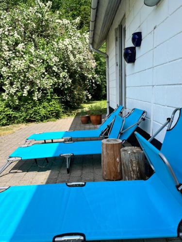 a group of blue chairs sitting on a porch at Fred og Ro Ferielejlighed in Ulstrup
