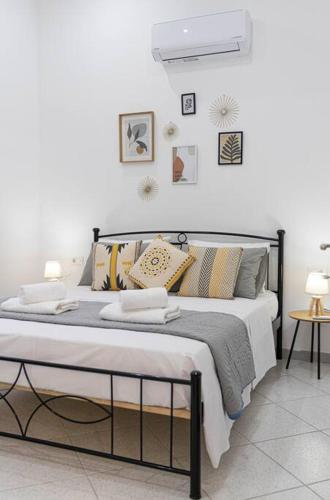 a white bedroom with a large bed with pillows at Nikolias dream house in Ialysos