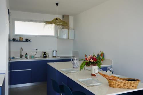 una cucina con armadi blu e piano di lavoro di sur la plage ! a Valras-Plage