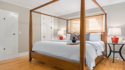 a bedroom with a canopy bed with a wooden frame at Chocolate Diamond private hot tub walk to Main in Fredericksburg