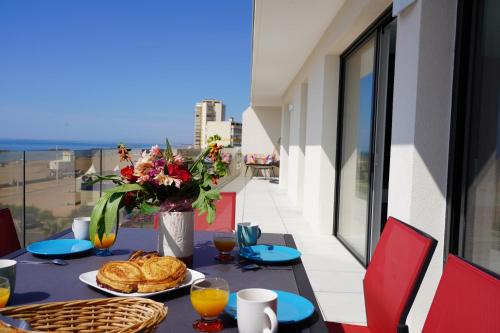 une table avec des assiettes de nourriture sur un balcon dans l'établissement sur la plage !, à Valras-Plage