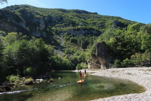 two people standing on kayaks in a river at Gîte La Petite Longère in Septfonds