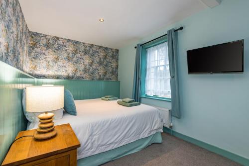 a bedroom with a bed and a flat screen tv at The Queens in Carlisle