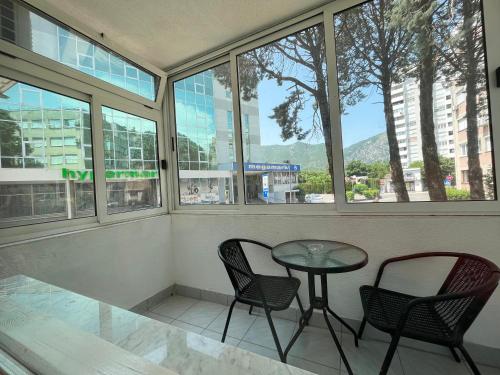 Starlux apartment في موستار: طاولة وكراسي في غرفة بها نوافذ
