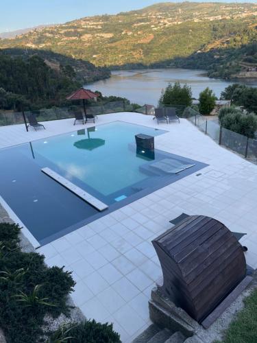 uma grande piscina com vista para um lago em Quinta Das Quintas & Spa em Baião