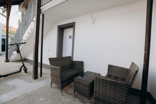 two wicker chairs and a table in a building at Apartmani Otašević in Kladovo