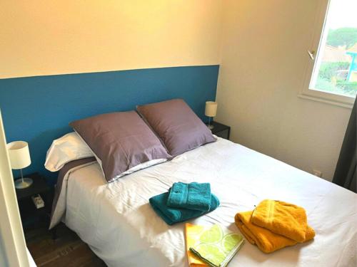 ein Bett mit zwei Handtüchern darüber in der Unterkunft Horizon Océan 1 - Superbe appartement 2 pièces avec parking privatif in Capbreton