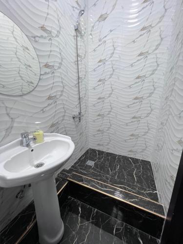 W łazience znajduje się umywalka i lustro. w obiekcie Cosmos Hotel w mieście Biszkek