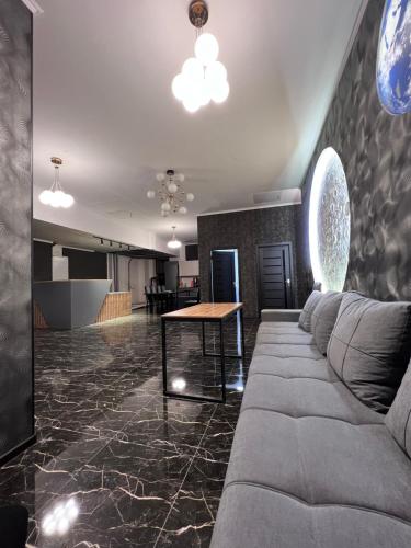 Cosmos Hotel في بيشكيك: غرفة معيشة مع أريكة وطاولة