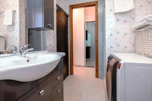 uma casa de banho com um lavatório e uma máquina de lavar roupa em Design House 15min to City - Wifi & Free Parking em Verona