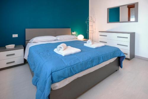 um quarto azul com uma cama com toalhas em Design House 15min to City - Wifi & Free Parking em Verona