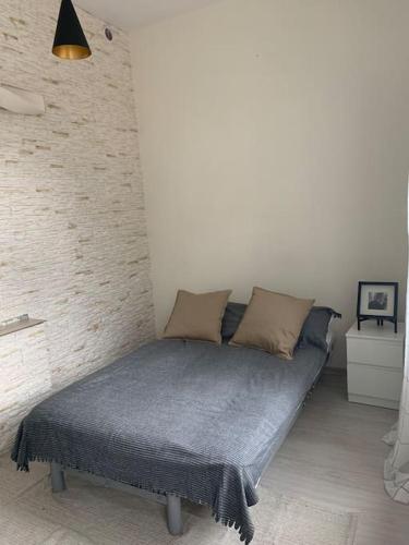a bed in a room with a brick wall at apartament- Stare Miasto Olsztyn in Olsztyn