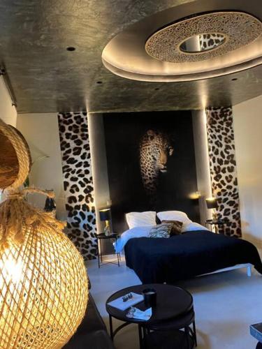 une chambre avec un lit bleu et un plafond avec aigunigunigun dans l'établissement Esprit AFRICA, SPA et SAUNA de luxe, à Mulhouse