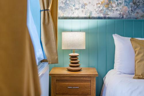 a lamp on a night stand next to a bed at The Queens in Carlisle