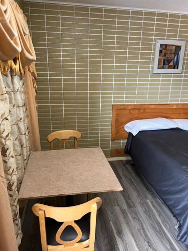 a small room with a table and a bed at Motel 66 in Transcona