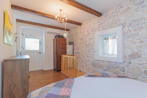 a bedroom with a stone wall with a bed at Traditional holiday house by the sea in Preko