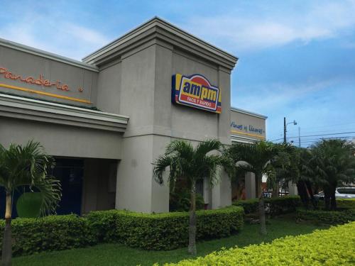 a building with a sign on the side of it at Casa Cafetal Aeropuerto in Alajuela City