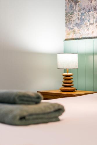 a bed with a lamp on a side table at The Queens in Carlisle
