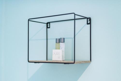 a glass shelf with a bottle and a candle on it at The Queens in Carlisle