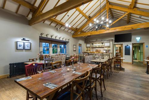 a dining room with wooden tables and chairs at The Queens in Carlisle