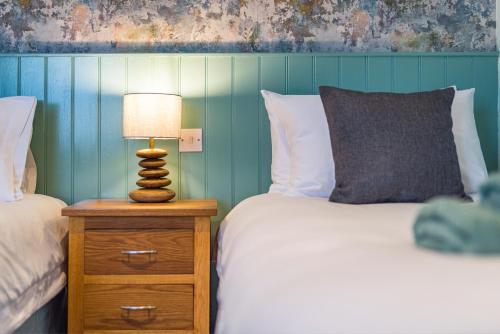 a bedroom with a bed and a lamp on a night stand at The Queens in Carlisle