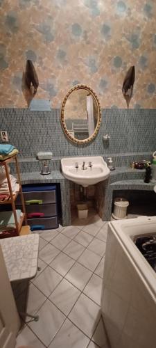 bagno con lavandino e specchio di Chez Virginie - chambre du Bourg a Lourdes