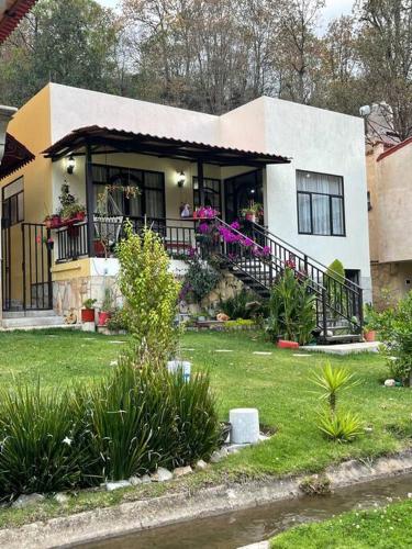 una casa con balcón con flores en el patio en Hermosa casita con vista al río., en San Cristóbal de Las Casas