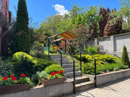 un conjunto de escaleras en un jardín con flores en Oreo Apartman, en Eger