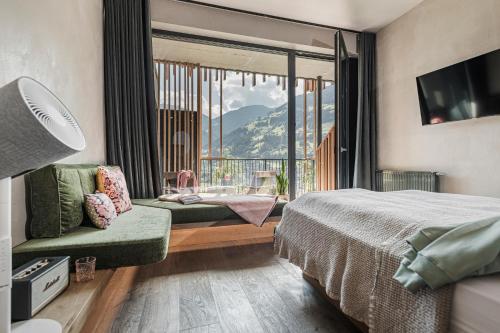 ein Hotelzimmer mit einem Bett und einem großen Fenster in der Unterkunft Coolnest in Mayrhofen