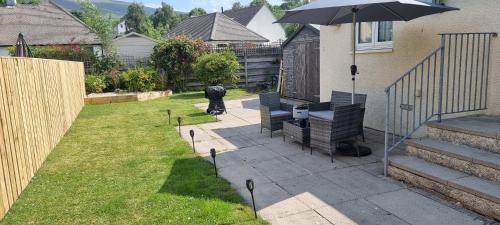 a person standing in a yard with an umbrella at Plum Cottage in Keswick