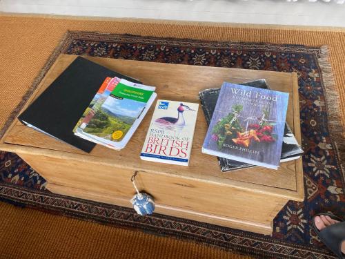 einen Holztisch mit Büchern darüber in der Unterkunft Hideaway in the Hills in Church Stretton