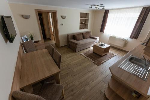 a living room with a table and a couch at Belvárosi Nemes Apartmanház Szekszárd in Szekszárd