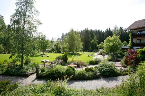 a garden with many plants and trees and a building at Hotel Waldblick Kniebis in Kniebis