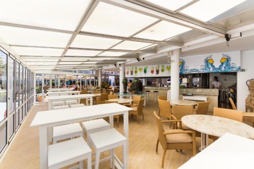 una vista interior de un restaurante con mesas y sillas en Jutlandia Family Resort, en Santa Ponsa