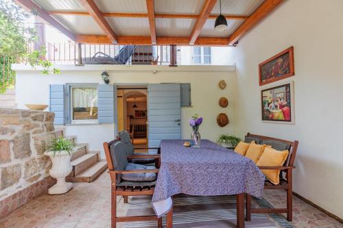 a dining room with a table and chairs on a patio at Traditional holiday house by the sea in Preko