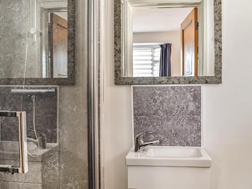 a bathroom with a sink and a mirror and a shower at Number 12 in Poole