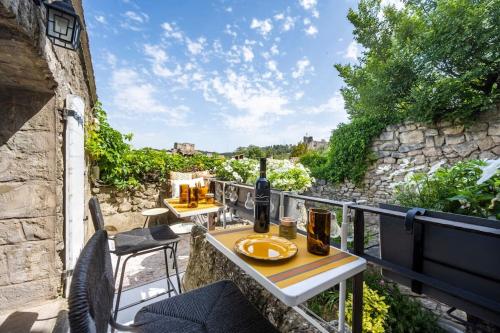 a patio with two tables and chairs on a balcony at le Balcon du Prince Noir in Les Baux-de-Provence