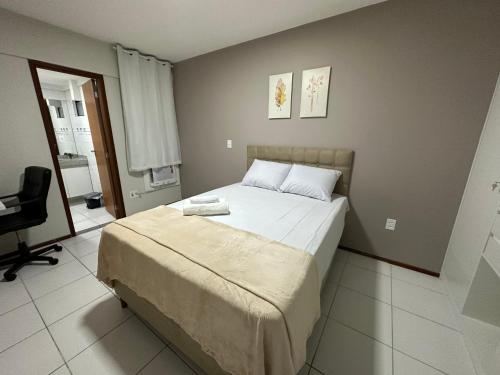 um quarto com uma cama e uma cadeira em 02 QUARTOS, a 200 metros da PRAIA de PAJUÇARA em Maceió