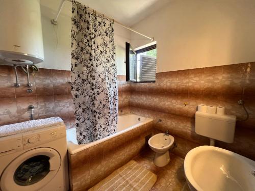 uma casa de banho com uma banheira, um WC e um lavatório. em Apartmani Rosa em Turanj