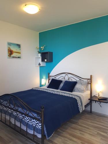 una camera con un grande letto con una parete blu di Apartment and rooms Parus a Capodistria