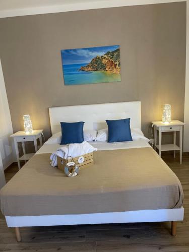 a bedroom with a large bed with blue pillows at B&B La Torre in Realmonte