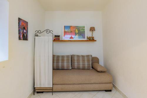 a couch in a living room with a curtain at Traditional holiday house by the sea in Preko