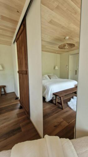 a mirror in a room with a bed and a table at Wabi sabi lodge&spa in Turenne