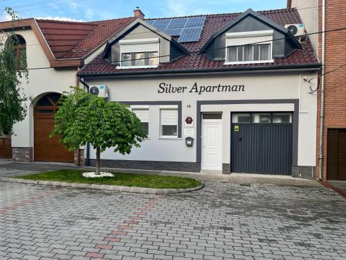 un edificio bianco con un cartello per un appartamento in capanna di Silver Apartman a Eger