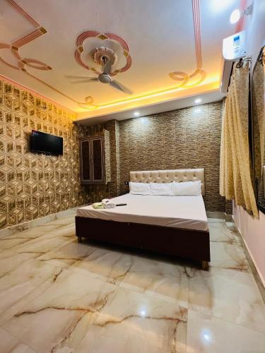 a bedroom with a bed and a tv on a wall at The Bella Guesthouse in Varanasi