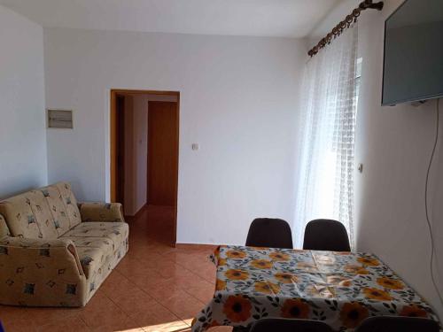 a living room with a couch and a table at Apartment Lopar, Primorje-Gorski Kotar 5 in Lopar
